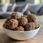 Close-up view of homemade energy balls with a shiny exterior, showcasing their round shape and texture.