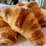 Close-up view of a croissant filled with creamy pastry cream.