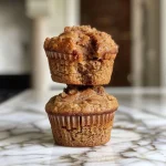 ['A side view of a moist gingerbread muffin with a golden-brown top.', 'Close-up of a fluffy gingerbread muffin, showcasing its spiced texture.', 'A delicious gingerbread muffin displaying a warm, inviting color.', 'A freshly baked muffin with a moist crumb and rich gingerbread flavor.']