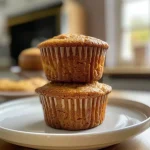 ['Close-up of a warm gingerbread muffin with a golden-brown crust and light glaze.', 'Side view of a fluffy gingerbread muffin topped with a sprinkle of powdered sugar.', 'Juicy and spiced gingerbread muffin showcasing a moist interior.', 'Detailed image of gingerbread muffins with a festive appearance, highlighting their texture.']