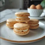 Close-up side view of colorful macarons on a plate.