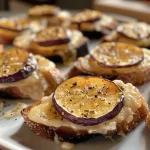 ['Close-up view of roasted figs with goat cheese and thin slices of lonzo.', 'Side profile of juicy roasted figs topped with goat cheese and lonzo.', 'Detailed image of succulent figs with creamy cheese and charcuterie.', 'Side shot showcasing roasted figs garnished with goat cheese and lonzo slices.']