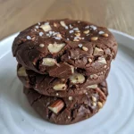 Close-up of a chocolate cookie with pecans, showing a rich texture.