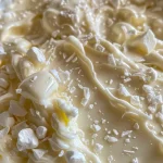 Close-up of creamy white chocolate spread in a jar.