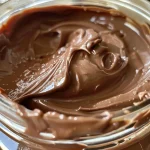 Close-up view of homemade chocolate hazelnut spread in a jar.