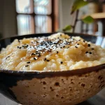 A creamy bowl of riz au lait à l'ancienne topped with a vanilla pod.