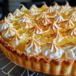 Close-up side view of a delicious lemon meringue tart topped with fluffy meringue.