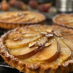 Close-up view of Tarte Bourdaloue, showcasing poached pears and almond cream on a golden pastry crust.